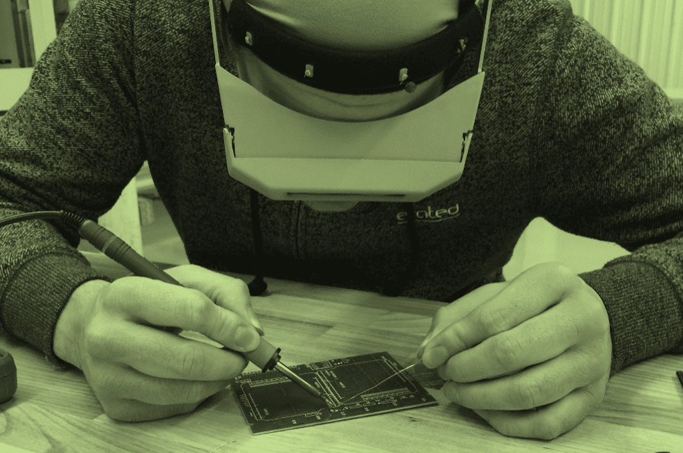 Engineer soldering circuits on a printed circuit board