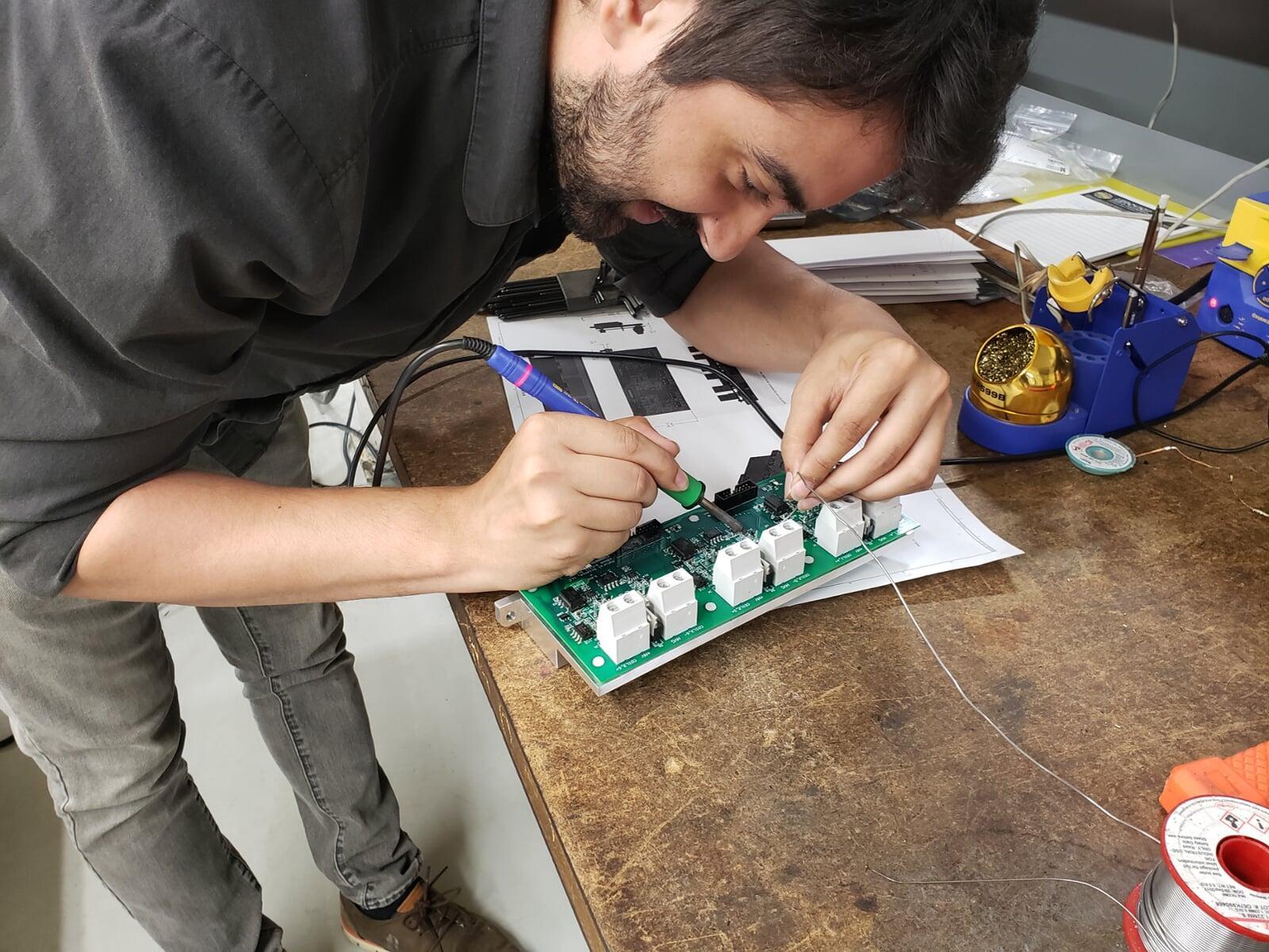 A technician soldering a high-power FETT circuit board